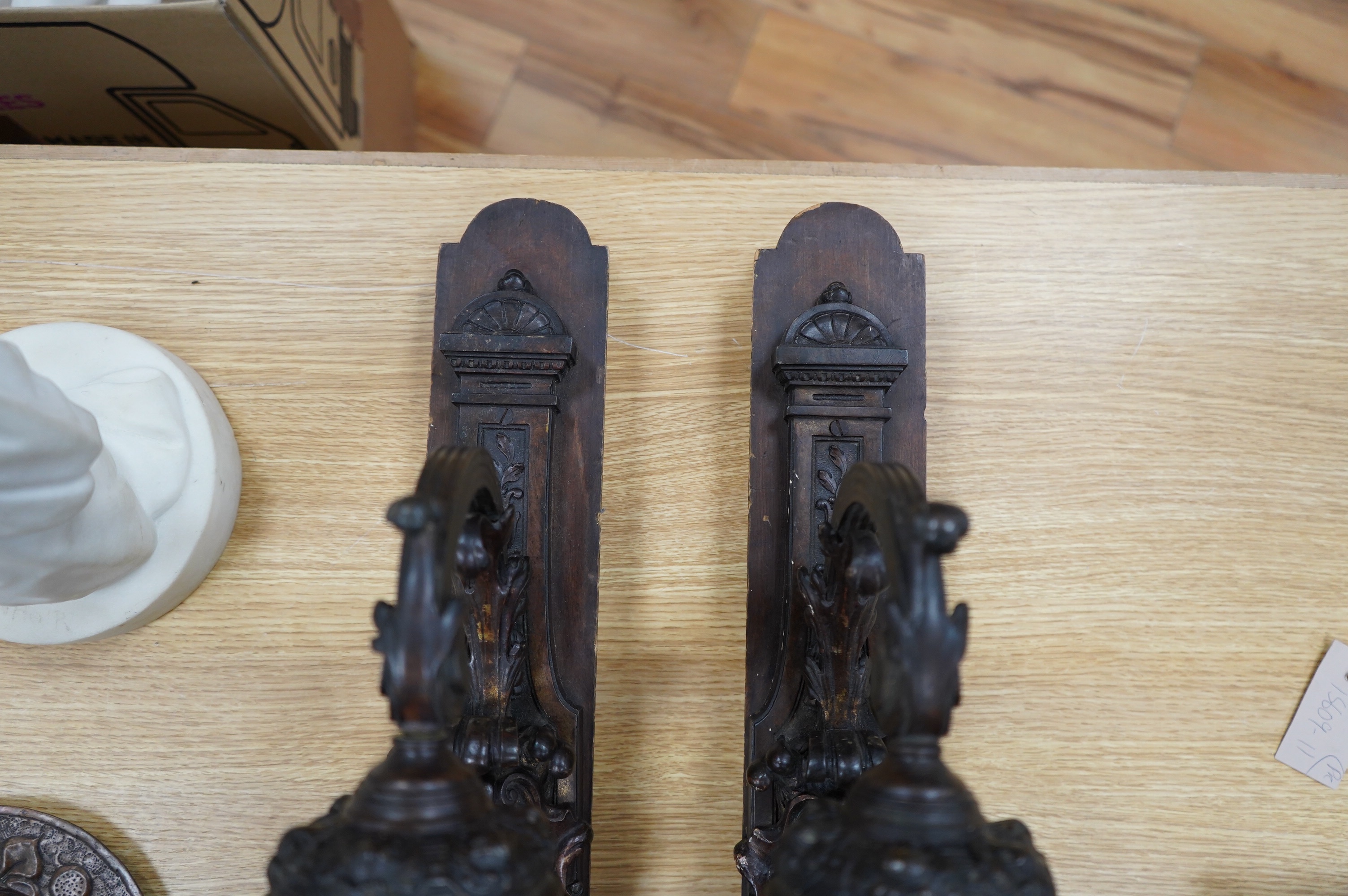 A pair of French bronze wall lights, c.1900 decorated with masks, mounted on wooden plinths, 54cm high. Condition - poor to fair